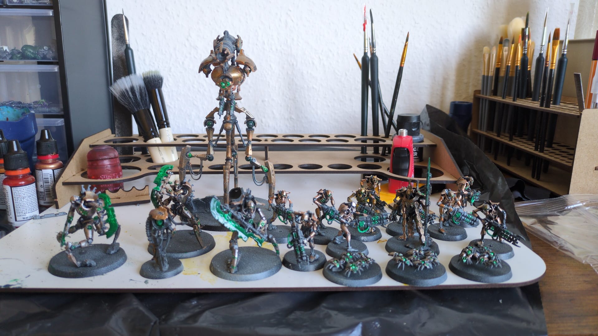 A Necrons combat patrol from Warhammer 40k. Necrons are robot-skeletons with Ancient Egypt motifs and fancy energy weapons. The patrol is composed of 10 necron warriors, an Overlord with tachyon arrow, three Canoptek Scarab Swarms, three Skorpekh Destroyers (tripodal versions of the skeletons, with big bladed weapons instead of guns), and a Canoptek Doomstalker (a tall mech with a big gun). Their armour is painted in bronze, with lots of green as the accent colour.