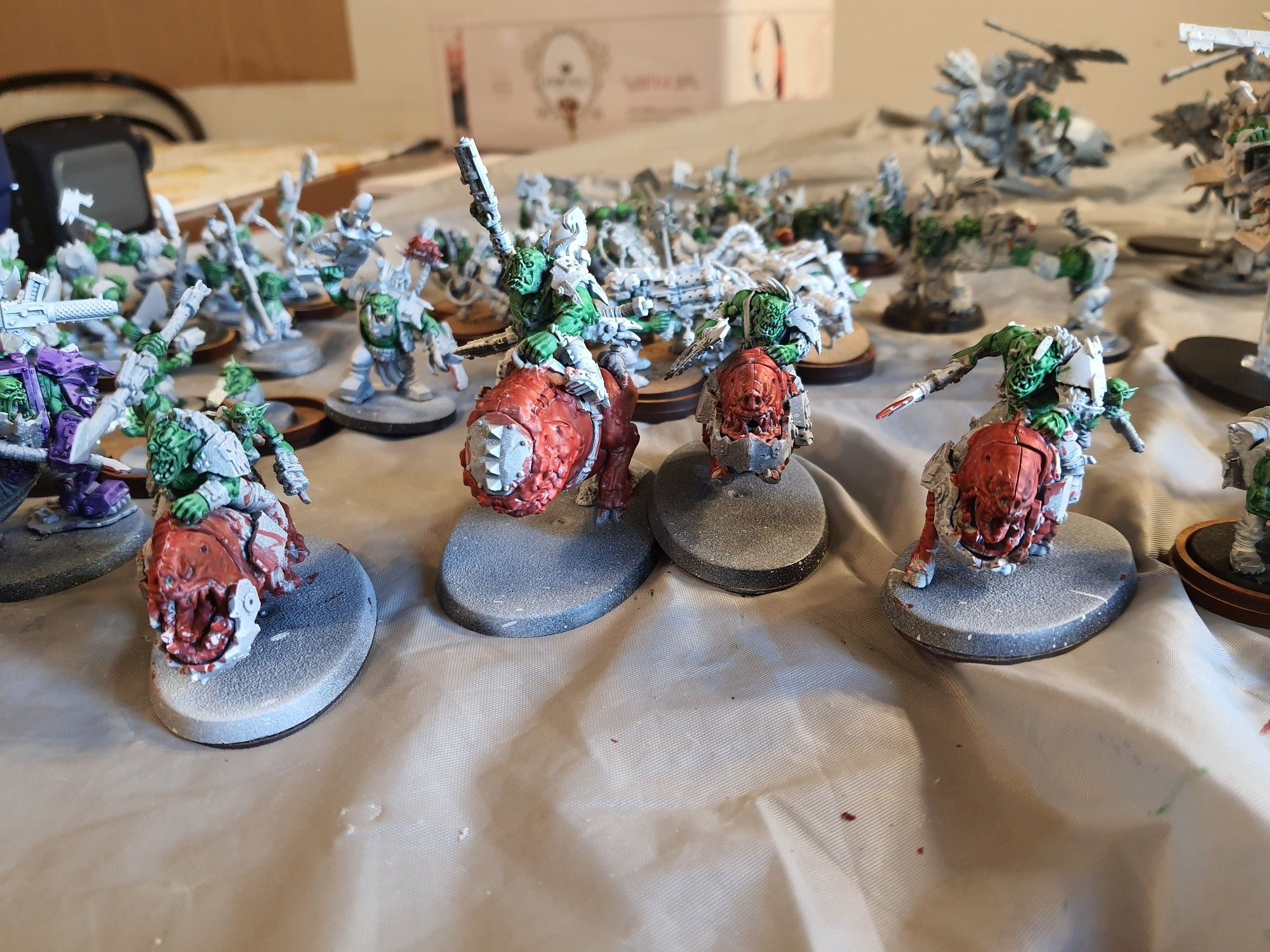 A squad of Squighog Boyz, led by a Nob on Smasha Squig. Their mounts are painted in Blood Angels Red, while the Orks and Grots are painted in contrast green. The rest of the minis remain base coated in white, but one of the spears has blood marks in it.